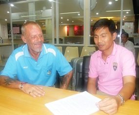 A friendly Immigration officer helps Smith (left) with the paperwork needed to deport him back to England.